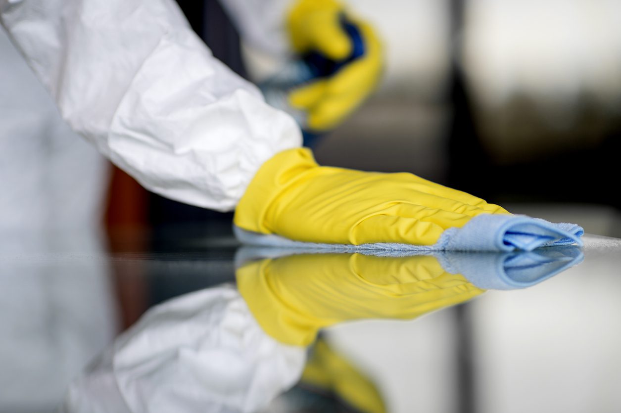 Cleaning professionals disinfecting office desks and high touch areas